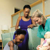 <p>Tania Thorbourne and her
daughter London visiting Eileen Margenat, RN, of the RNICU.</p>