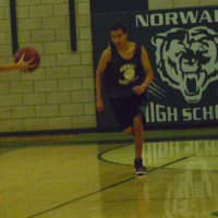 <p>Norwalk boys basketball players run a drill at practice.</p>