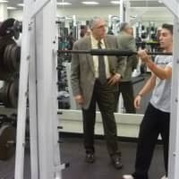 <p>A Harrison High School student shows off a barbell to Principal James Ruck.</p>