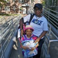 <p>Miracle Caesar, 5, shows off her new backpack, along with mom, Belinda. Both are from Washington Village in Norwalk. </p>
