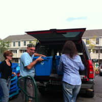 <p>Volunteers loading bins of food from a food run</p>