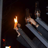 <p>The first candle on the menorah outside 400 Post Road E. in Westport is lit by resident Mark Jaffe. Menorahs are lit from right to left.</p>