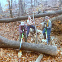 <p>A large piece of a fallen tree is rolled off the hiking trail. From left, Mike Salowey, Mike Surdej and David Emerson.</p>