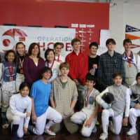 <p>The competitors in Saturday&#x27;s tournament take a photo with Operation Hope Executive Director Carla Miklos at the Fairfield Fencing Academy.</p>