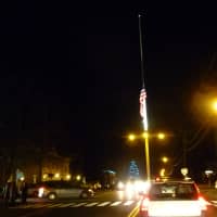 <p>The flag at the giant flagpole on Main Street in Newtown flies at half staff. </p>