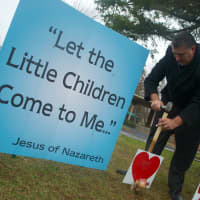 <p>A congregation member at Eastchester Community Church leaves a message of sympathy at the church&#x27;s memorial garden for victims of Friday&#x27;s shooting at Sandy Hook Elementary School in Newtown, Conn.
</p>