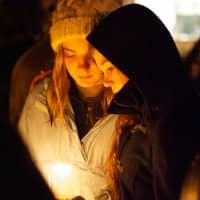 <p>Two girls hold a candle at a vigil on the Village Green in Rye on Sunday night for Friday&#x27;s shooting at Sandy Hook Elementary School in Newtown, Conn.</p>