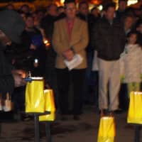 <p>Volunteers light 26 candles inside bags with the names of those who were killed in Sandy Hook School on Friday.</p>