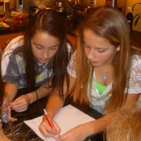 <p>Greenwich middle school students Julia Hryckwian, left, 11, and Molly Spaeth, 12, write a letter of support to Sandy Hook Elementary School in Newtown.</p>