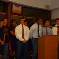 <p>Horace Greeley High School football captain Teddy Graves (at podium) was joined by teammates in support of coach Bill Tribou at a Board of Education meeting May 1.</p>
