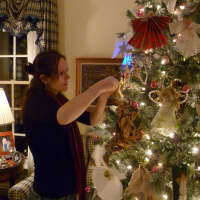 <p>Ember Hobi of New Canaan decorates the angel tree being created in honor of Emilie Parker, one of 20 children who died at Sandy Hook Elementary School in Newtown last Friday. </p>