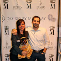 <p>Tara and Scott Mikolay, owners of Desires by Mikolay, pose with a stuffed animal pug. Their own pug, Mini, was back at home. </p>