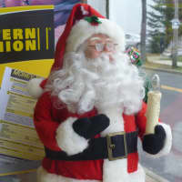 <p>A Santa Claus doll looking out the window at The Harrison Deli. </p>