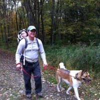 <p>Land trust member Shaun Malay, of Easton, walks a dog at Trout Brook Valley.
</p>