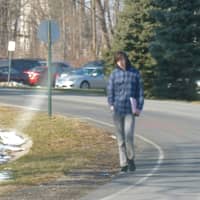 <p>A Westchester Community College student walks into campus from Grasslands Road. The college&#x27;s student government is hoping the state will provide funding for sidewalks to increase student safety.</p>