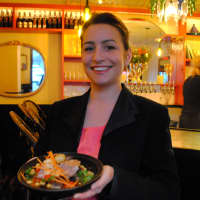<p>Leila D&#x27;heurle stands with a short rib tagine in the bar area of Tagine. </p>