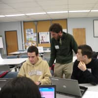 <p>Paul Monaghan from Dobbs Ferry High School, left, and Nicholas Jacobino, Walter Panas High School, met with teacher Travis Hayes at a symposium in Yorktown Heights.</p>