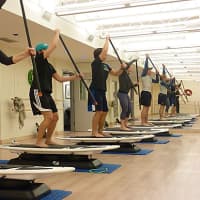 <p>To simulate paddle boarding, a group of exercisers use weighted body bars during a workout at Downunder Fitness &amp; Surf in Westport.</p>