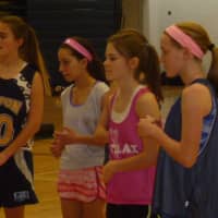 <p>Girls listen at the basketball camp Monday at Weston High School.</p>