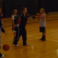<p>Weston High School assistant coach Anna Balouskas works with a player on shooting form.</p>