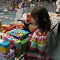 <p>Six-year-old Kathleen Galvin, a first-grader at Scotland Elementary School, looks at the some of the many games and toys for sale.  </p>