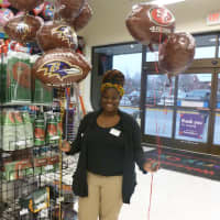 <p>Gabrielle Vanderpuije, an employee at Greenburgh&#x27;s Party City, stands in front of the store&#x27;s selection of Super Bowl party items.</p>