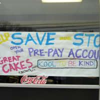 <p>A sign outside Great Cakes Wednesday urges residents to help keep the shop in business.</p>