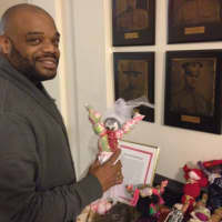 <p>Byron Smalls displays a wedding dress doll made by a White Plains Youth Bureau student to raise money for the youth programs. </p>
