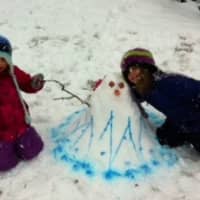 <p>Isabel Torgerson, 4, left, and her sister Charlotte, 7, spent part of their Friday making a snowgirl they named Marina outside of their New Canaan home. </p>