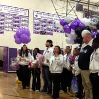 <p>New Rochelle varsity cheerleading coach Chrissy Stanionis addresses the crowd at the high school gymnasium.</p>
