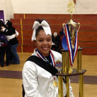 <p>New Rochelle senior varsity cheerleader Alejandra Toro hoists the national championship trophy.</p>