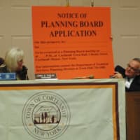 <p>Supervisor Linda Puglisi and Town Attorney Tom Wood hold up a Planning Board application notice. These notices are placed  on the front of buildings that are the subject of Planning Board applications. </p>