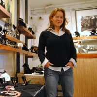 <p>Jennifer Rutheny stands by some of the work of invited jewelers, in her shop. </p>