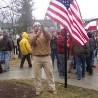 <p>A construction worker holds up a flag outside a Stamford work site to protest out-of-state workers being hired to work local jobs.</p>