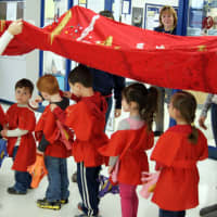<p>Walter Panas pre-K students walk under a dragon for the Chinese New Year parade.</p>