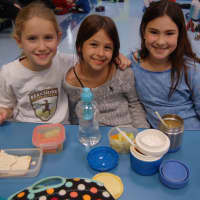 <p>Fourth-graders Chiara Polvara, Alexa Justman and Alyx Marvin show off their reusable lunch containers.</p>