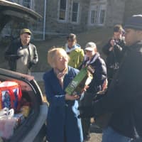 <p>Kat Klein (left) hands Jared Roman (right) a bag of pet food to donate to the Hudson Valley Pet Food Pantry on Tuesday. </p>