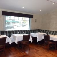 <p>Booth seating lines a wall in the dining room at 323 Main. </p>