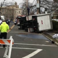 <p>A milk truck sits on its side after flipping over on Field Point Road on Monday morning.</p>