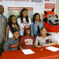<p>Hamilton coach Benjamin Carter, left, and members of the girls basketball team with Maia Hood, center, front, at her college signing.</p>