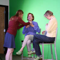 <p>Video Club advisor Cynthia Sandler adjusts the microphones.</p>