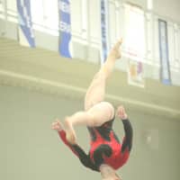 <p>Caroline Fitzpatrick of New Canaan competes on the balance beam.</p>