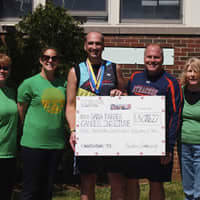 <p>Ty Powers collects a check for the Dana-Farber Cancer Institute after completing the Boston Marathon at S.J. Preston School in Harrison.</p>