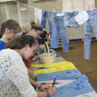 <p>Rye students write positive messages on donated pairs of genes for a &quot;Be Comfortable in Your Genes&quot; booth celebrating positive body image.</p>