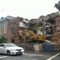 <p>Construction crews demolish the old central fire station on Wednesday to make way for the new $20 million station.</p>