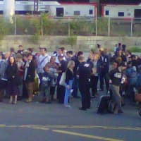 <p>Passengers wait for buses to take them away from the scene of a two-train collision.</p>