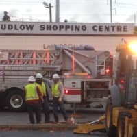 <p>Workers deal with the cleanup after a fire at the Ludlow Shopping Centre at Roger Square in East Norwalk on Thursday afternoon.</p>