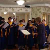 <p>Cindy Verost directs the Saddle Brook High School choir at a nursing home performance in early December.</p>