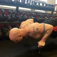<p>Phil Ross performs Nuero Grip pushups inside his American Eagle MMA studio.</p>