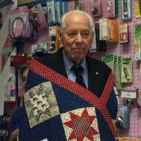 <p>A veterans is wrapped in a quilt at Christie&#x27;s Quilting Boutique in Norwalk.</p>